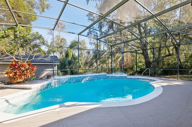 view of pool with a patio, pool water feature, and glass enclosure