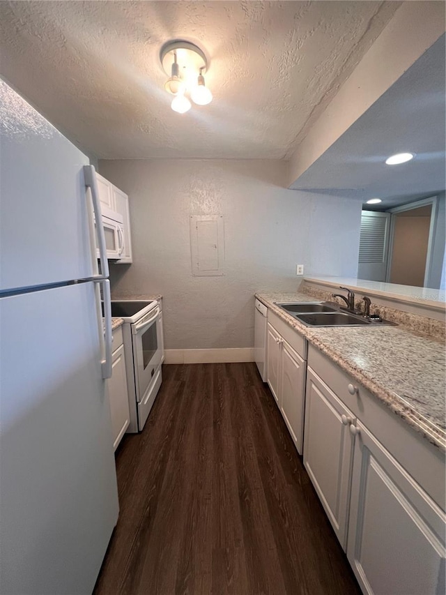 kitchen with white appliances, white cabinets, a textured ceiling, dark wood-type flooring, and sink