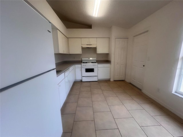 kitchen with white appliances, a textured ceiling, light tile patterned flooring, and white cabinets