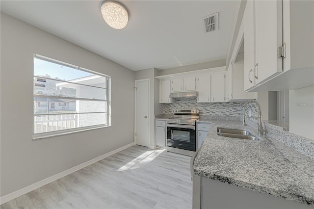 kitchen with white cabinetry, stainless steel electric range oven, sink, tasteful backsplash, and light stone counters