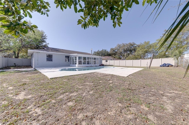 back of property featuring a sunroom, a patio area, and a yard