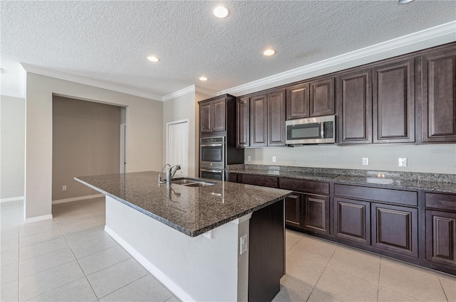 kitchen with a center island with sink, light tile patterned floors, stainless steel appliances, and sink