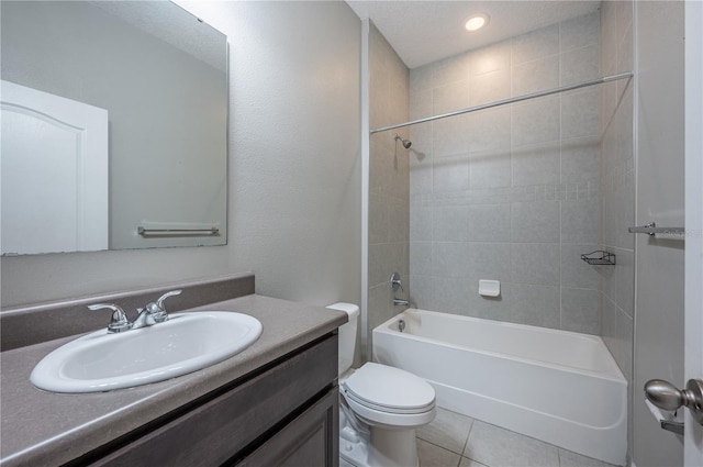 full bathroom with vanity, tile patterned flooring, tiled shower / bath combo, toilet, and a textured ceiling