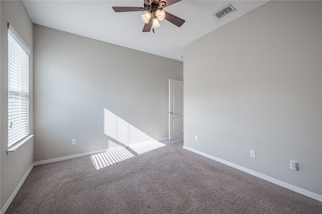 unfurnished room with ceiling fan and carpet