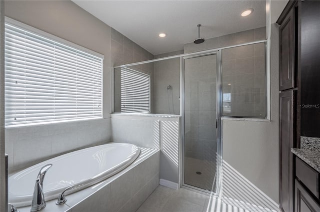 bathroom featuring tile patterned flooring, vanity, and separate shower and tub