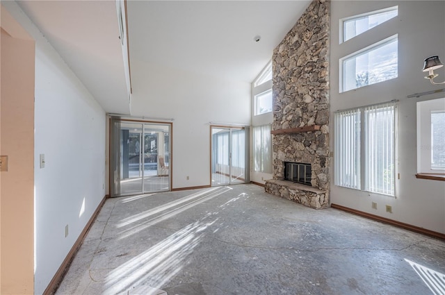 unfurnished living room featuring high vaulted ceiling and a stone fireplace