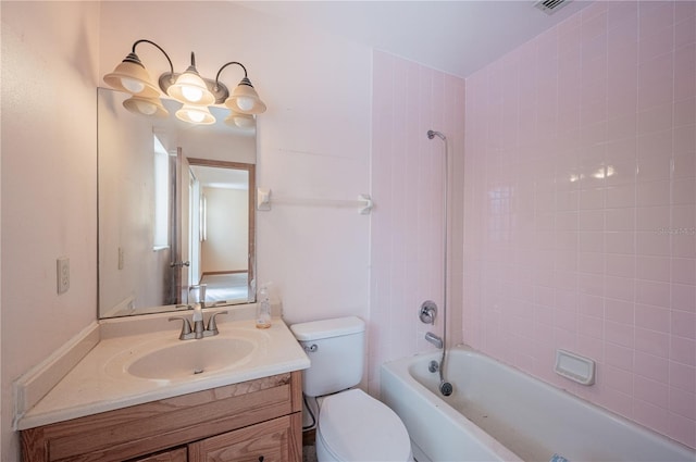 full bathroom featuring vanity, tiled shower / bath, and toilet