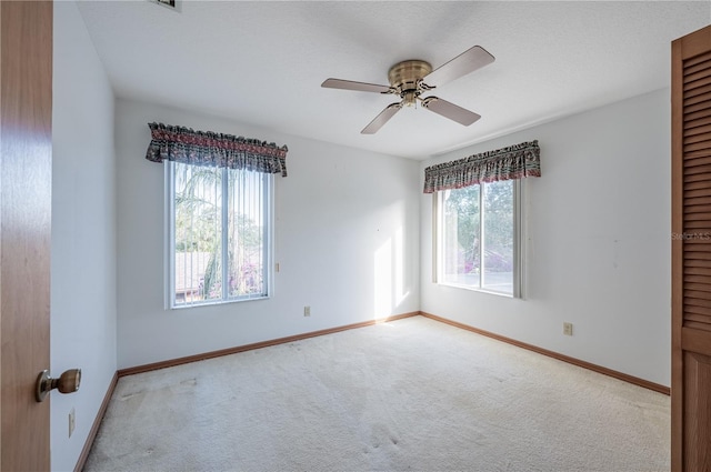 empty room featuring light carpet and ceiling fan