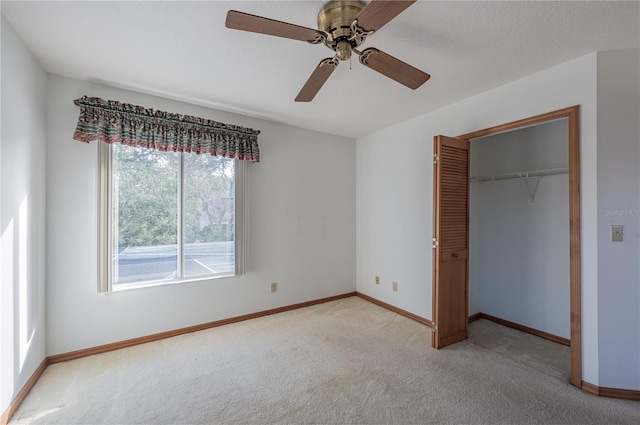 unfurnished bedroom with ceiling fan, a closet, and light carpet