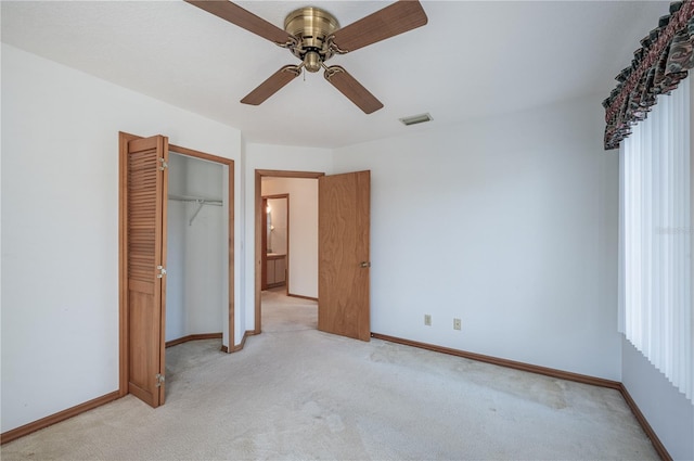 unfurnished bedroom featuring light carpet, a closet, and ceiling fan