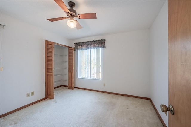 unfurnished bedroom with ceiling fan, light carpet, and a closet