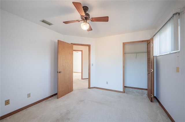 unfurnished bedroom featuring ceiling fan, a closet, and light colored carpet