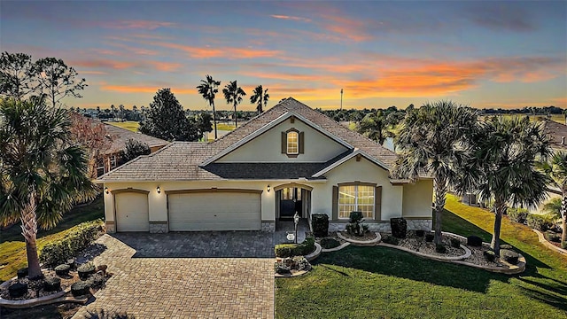 single story home with a lawn and a garage