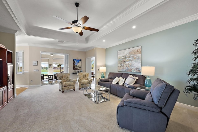 living room with light carpet, a raised ceiling, ceiling fan, and crown molding