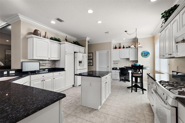 kitchen with white appliances, an inviting chandelier, crown molding, a kitchen island, and white cabinetry