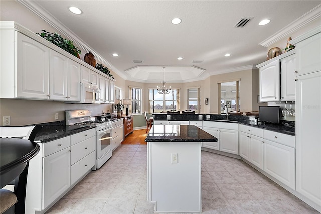 kitchen with kitchen peninsula, white cabinets, and white appliances