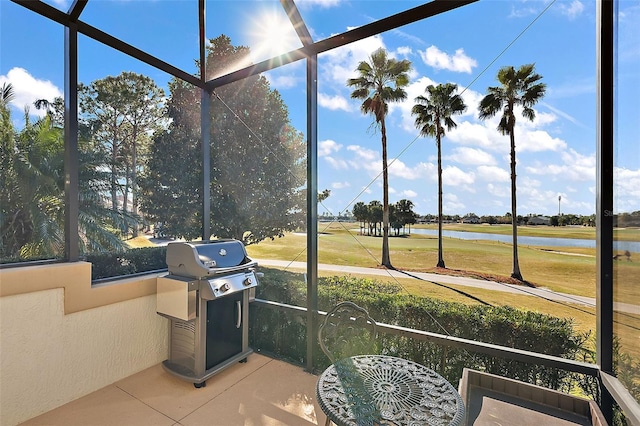 sunroom featuring a water view