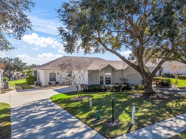 single story home with a garage, a front yard, and central AC