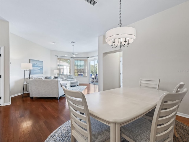 dining space with dark hardwood / wood-style floors and ceiling fan with notable chandelier