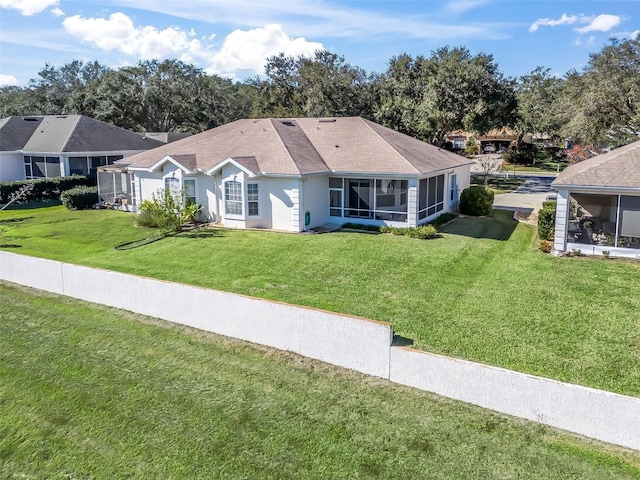 ranch-style home featuring a front lawn and a sunroom