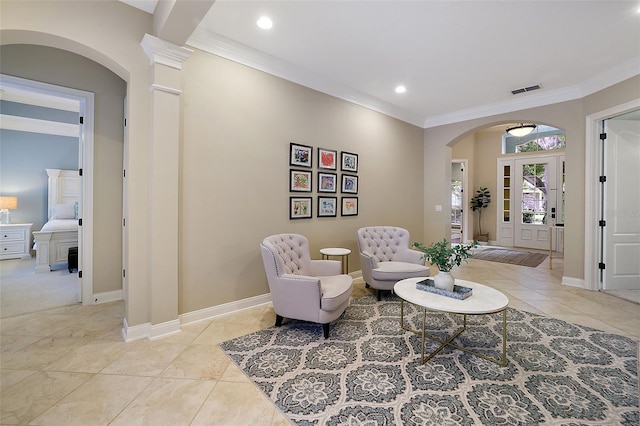 sitting room with crown molding and light tile patterned floors