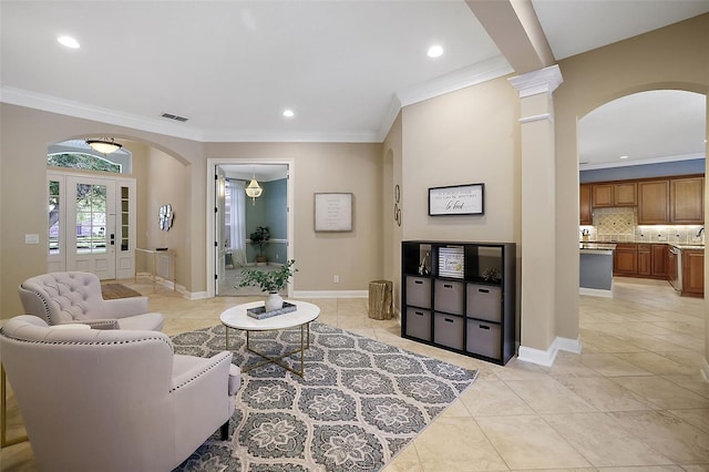 living room featuring light tile patterned floors, ornate columns, and ornamental molding