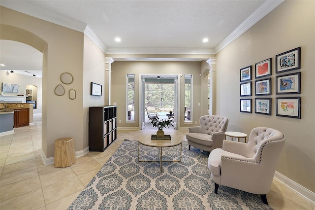 living area featuring a textured ceiling, ornate columns, crown molding, and light tile patterned flooring