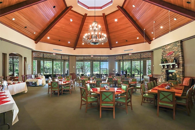 carpeted dining room featuring a fireplace and high vaulted ceiling