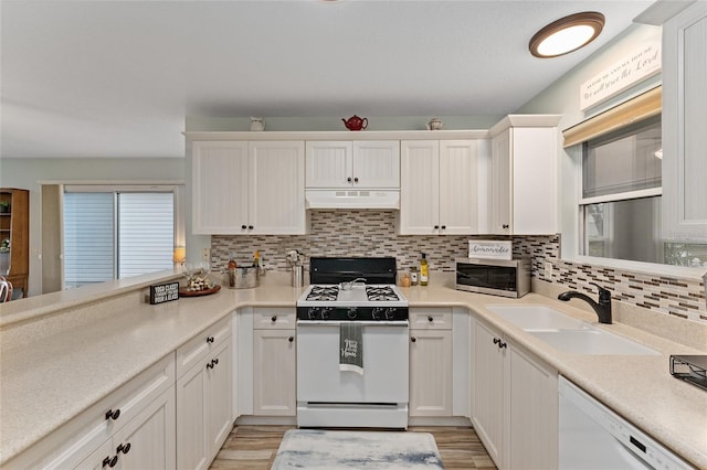 kitchen featuring sink, white appliances, light hardwood / wood-style floors, decorative backsplash, and white cabinets