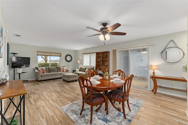 dining room with ceiling fan, a textured ceiling, and light hardwood / wood-style floors