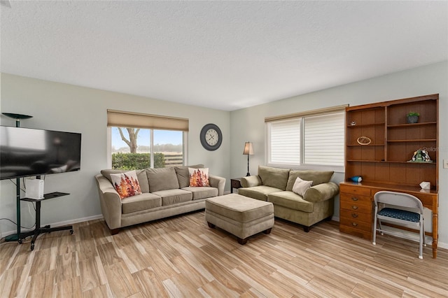 living room featuring plenty of natural light, a textured ceiling, and light wood-type flooring