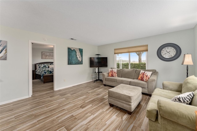 living room featuring light hardwood / wood-style floors and a textured ceiling