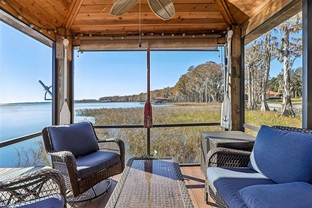 sunroom / solarium with a water view, ceiling fan, and wooden ceiling