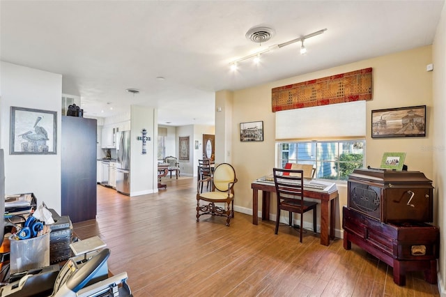 miscellaneous room featuring hardwood / wood-style floors and track lighting