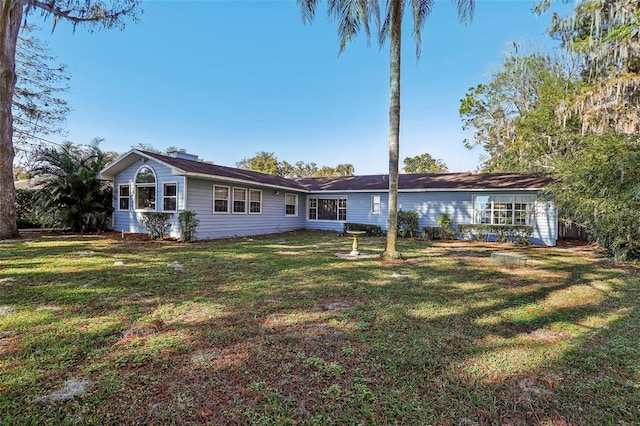 back of property featuring a lawn