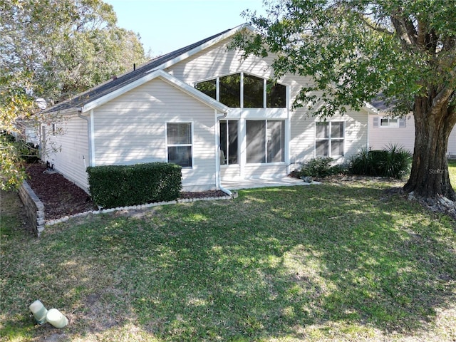 back of house featuring a yard and a sunroom