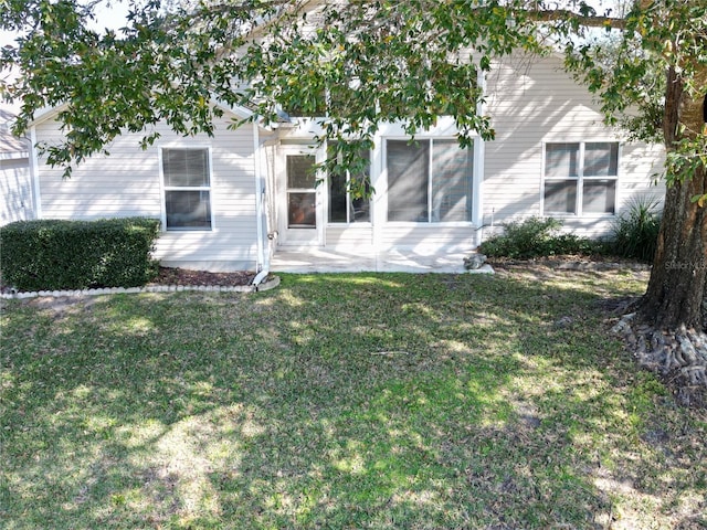 rear view of property featuring a yard