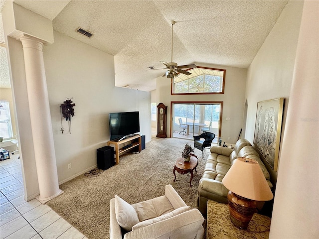 tiled living room with decorative columns, ceiling fan, high vaulted ceiling, and a textured ceiling