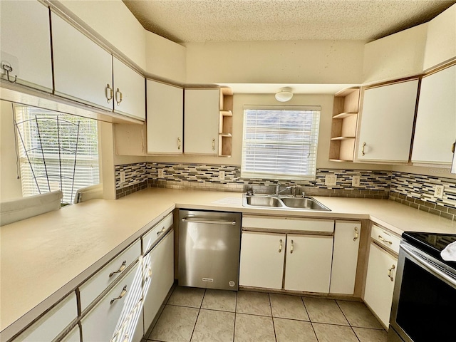 kitchen featuring sink, light tile patterned floors, a textured ceiling, tasteful backsplash, and stainless steel appliances