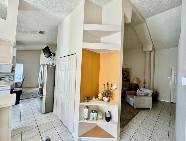 kitchen featuring built in features, stainless steel fridge, and light tile patterned floors