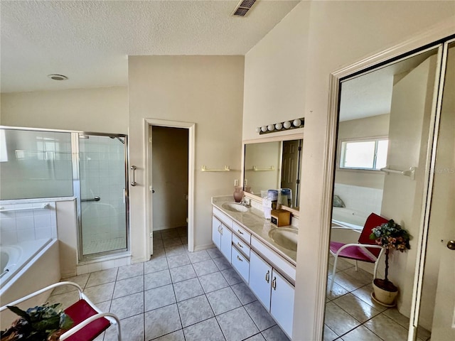 bathroom featuring tile patterned flooring, shower with separate bathtub, vanity, and a textured ceiling