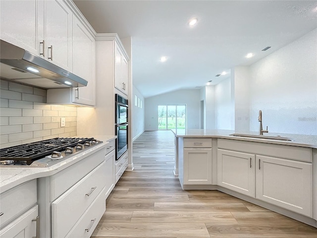 kitchen featuring stainless steel gas stovetop, lofted ceiling, white cabinets, sink, and light hardwood / wood-style floors