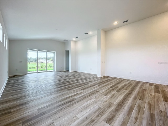 unfurnished living room featuring vaulted ceiling and light wood-type flooring