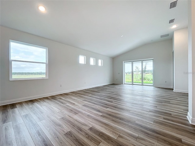 unfurnished room featuring light hardwood / wood-style flooring and vaulted ceiling