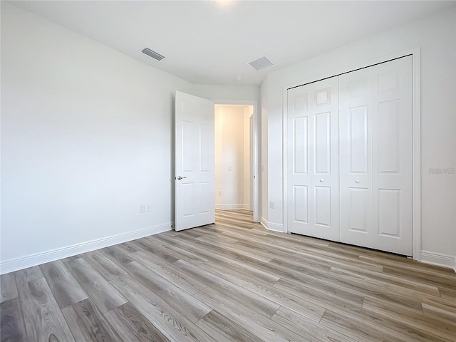 unfurnished bedroom featuring a closet and light hardwood / wood-style floors