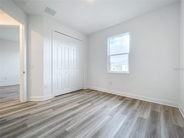 unfurnished bedroom featuring a closet and light hardwood / wood-style floors