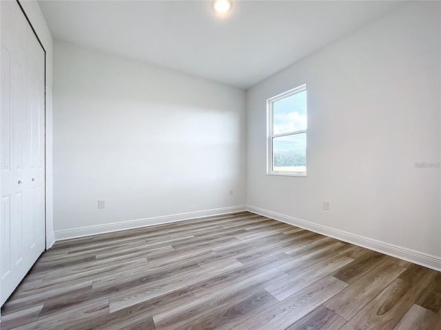 unfurnished bedroom featuring a closet and light hardwood / wood-style floors