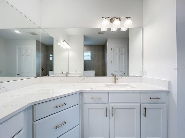 bathroom featuring tiled shower and vanity