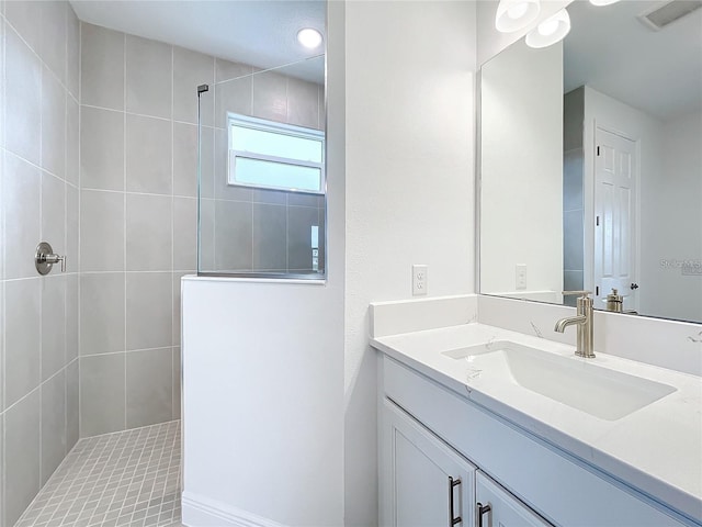 bathroom with vanity and a tile shower