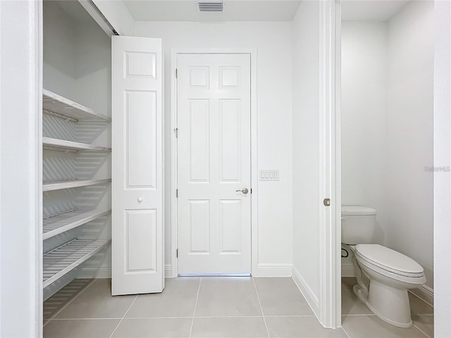 interior space featuring tile patterned floors and toilet